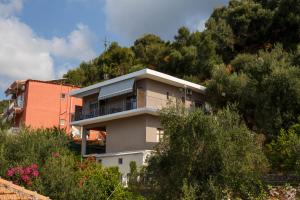 a building on the side of a hill with trees at Vivere studios in Parga