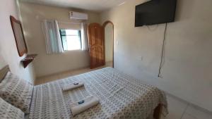 una camera da letto con un letto bianco con due asciugamani di Apart Hotel M6D a Rio Branco