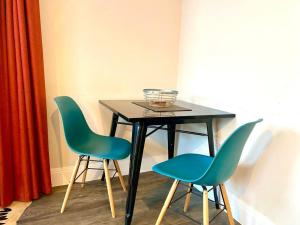 a table with two chairs and a bowl on top at Luxurious Studio Apartment - 1 Minute walk to Poole Quay - Great Location - Free Parking - Fast WiFi - Smart TV - Newly decorated - sleeps up to 2! Close to Poole & Bournemouth & Sandbanks in Poole