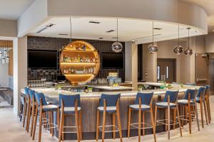 un bar en un restaurante con taburetes azules en Cambria Hotel Savannah Downtown Historic District, en Savannah
