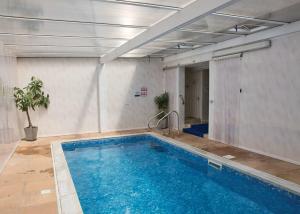 a large swimming pool in a room with at Exmoor Gate Lodges in Chipstable