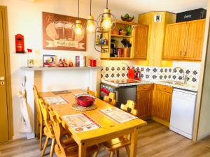 a kitchen with a wooden table and a table and chairs at Appart 3 Chambres - 8 pers - AU PIED DES PISTES in Valmeinier