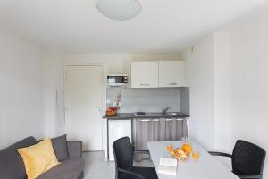 a kitchen and a living room with a table at Appart Hotel Corte HR in Corte