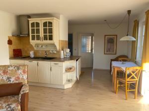 プレローにあるWolffsbauの白いキャビネットとテーブル付きのキッチンが備わります。