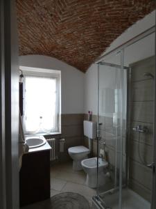 a bathroom with a toilet and a glass shower at Agriturismo Why Farm in Marano Ticino