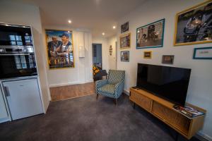 a living room with a flat screen tv and a chair at Bienvenue Chez Nous in Bergues