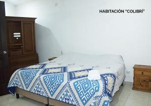 1 dormitorio con 1 cama con edredón azul y blanco en Departamentos Ileana en Cozumel