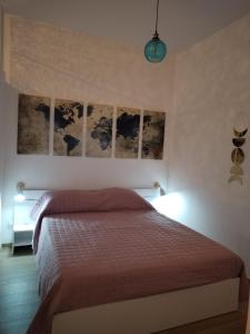 a bedroom with a bed and some paintings on the wall at Triremi house in Lido di Ostia