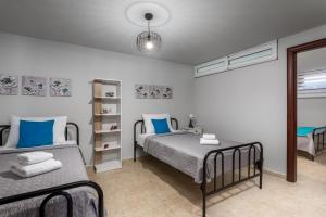 two beds in a bedroom with blue pillows at Mayas House Greece Rhodes Kremasti in Kremasti