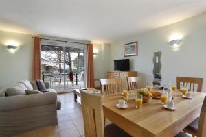 a dining room and living room with a wooden table at Vacancéole - Les Bastides de Fayence in Tourrettes