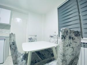 una mesa blanca y 2 sillas en una habitación en A Apartment Visegrad, en Višegrad