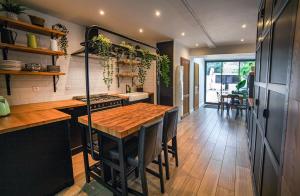 a kitchen with a wooden table and a wooden floor at Bienvenue Chez Nous in Bergues