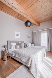 a bedroom with a large bed and a wooden ceiling at GOING TRIPLE A apartments NORTH in Going