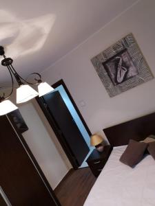 a bedroom with a bed and a lamp and a picture on the wall at APARTAMENT AUTENTIC RESIDENCE in Predeal