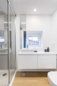 y baño blanco con lavabo y ducha. en Echo Homespaces Marquês en Sesimbra