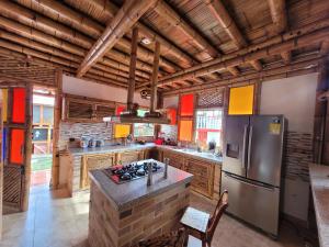 a large kitchen with wooden ceilings and a refrigerator at Chalet la texana in Filandia