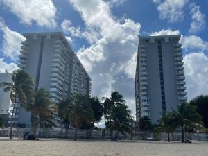 zwei hohe Gebäude am Strand mit Palmen in der Unterkunft 2 Bedrooms 2 Bathrooms Beach Front Apt @ Coral in San Juan