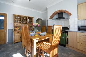 a kitchen with a wooden table and chairs at Cherry Tree Villa in Harrogate