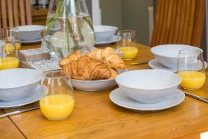 a table with plates of food and cups of orange juice at Cherry Tree Villa in Harrogate