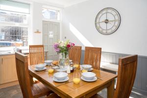 a dining room table with chairs and a vase of flowers at Cherry Tree Villa in Harrogate