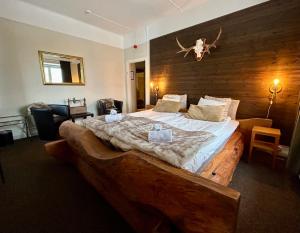 a bedroom with a large bed with a wooden headboard at Kungshaga Hotell in Orsa