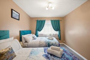 a bedroom with two beds and a window at Three Bed near London excel in Abbey Wood