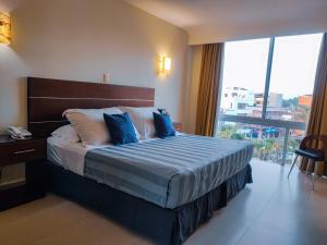 une chambre d'hôtel avec un lit et une grande fenêtre dans l'établissement May Palace Hotel , à Tuxpan