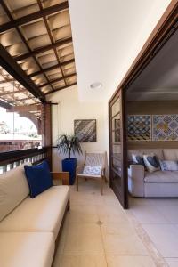 a living room with a couch and a chair at Batur 102 - Bali Bahia in Praia do Forte