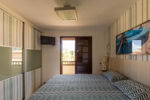 a bedroom with a bed and a view of the ocean at Batur 102 - Bali Bahia in Praia do Forte