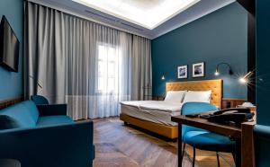 a hotel room with a bed and a desk and chairs at Palatinus Boutique Hotel in Pécs