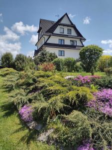 een groot wit huis met bloemen ervoor bij Pokoje Gościnne u Ady in Jurgów