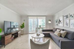 a living room with a couch and a tv at Centric Modern 40thFloor Brickell Condo FREE parking by Palermo Home Miami in Miami