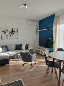 a living room with a couch and a table and chairs at Apartment Marlena in Mokošica