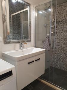 a white bathroom with a sink and a shower at Apartment Marlena in Mokošica +22 photos