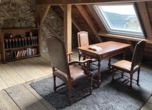 einen Holztisch und Stühle in einem Zimmer mit Fenster in der Unterkunft Denkmalgeschützter Bauernhof in Schauenstein