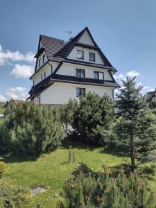 een groot huis bovenop een heuvel met bomen bij Pokoje Gościnne u Ady in Jurgów