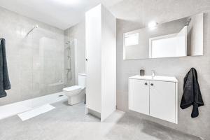 a white bathroom with a toilet and a sink at Sweet garden Las palmas in Las Palmas de Gran Canaria