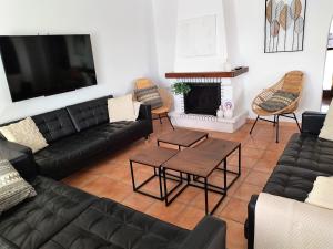 a living room with black leather furniture and a fireplace at Villa Martí in Calpe