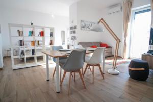 - un salon avec une table à manger et des chaises dans l'établissement Rossani Suites&Aparts, à Bari