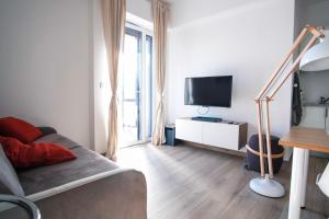 - un salon avec un canapé et une télévision dans l'établissement Rossani Suites&Aparts, à Bari