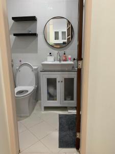 uma casa de banho com um lavatório, um WC e um espelho. em Grandview 312 - 1BR Condo Near Burnham Park em Baguio