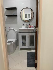 Un baño con lavabo, inodoro y espejo. en Grandview 312 - 1BR Condo Near Burnham Park, en Baguio 50 fotos más