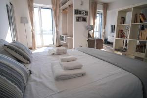 ein großes weißes Bett mit Handtüchern darüber in der Unterkunft Rossani Suites&Aparts in Bari