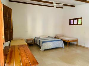 ein Schlafzimmer mit einem Bett und einer Bank darin in der Unterkunft Pousada Sem Stress Porto Itália in Nova Viçosa