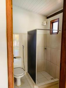 a bathroom with a toilet and a shower at Pousada Sem Stress Porto Itália in Nova Viçosa