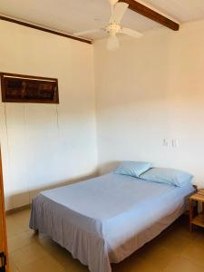 Bett in einem Zimmer mit Deckenventilator in der Unterkunft Pousada Sem Stress Porto Itália in Nova Viçosa