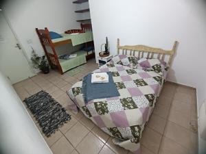 a bedroom with a bed with a quilt on it at Suítes da Val in Paraty