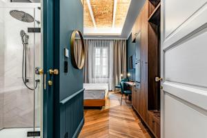a room with a bed and a door with a mirror at Palatinus Boutique Hotel in Pécs