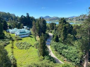 ヌワラエリヤにあるTHE WIND LILY - Lake View Luxury Apartmentの道路横の丘の上の家屋