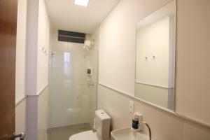 a bathroom with a toilet and a sink and a mirror at Samba Belo Horizonte Vintage in Belo Horizonte